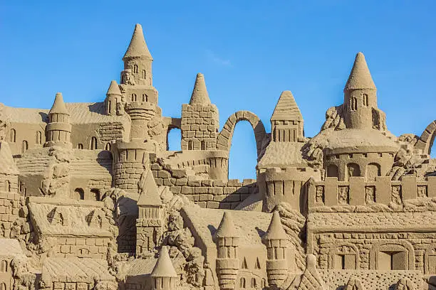 Sand castle with many towers against a blue sky