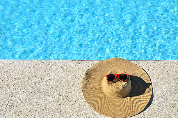 istock Sun hat and sunglasses beside the blue pool 521820917