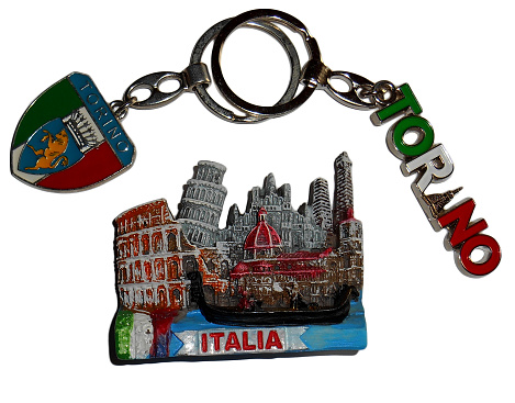 Isolated close up view of two key chains and one fridge magnet from Italy.