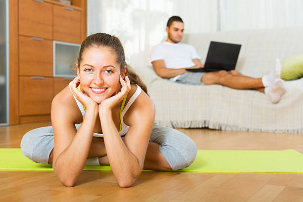 istock female in yoga position and lazy guy on sofa 521829557