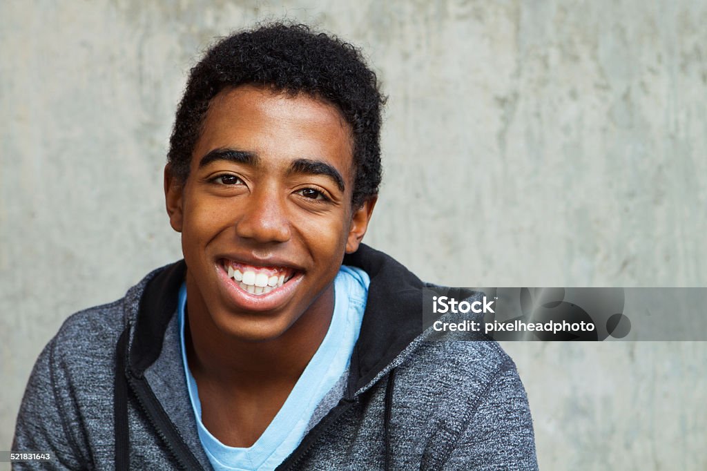 African American Teenager Smiling Portrait of a young African American teenager on a grey background. Teenager Stock Photo