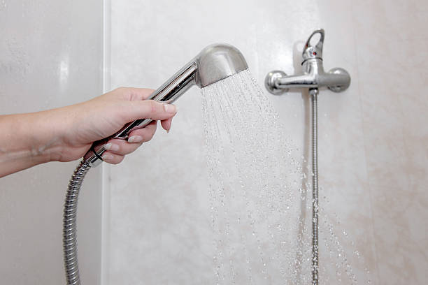 Retención cabezal de ducha de mano de la mujer con el vertido de aguas domésticas - foto de stock