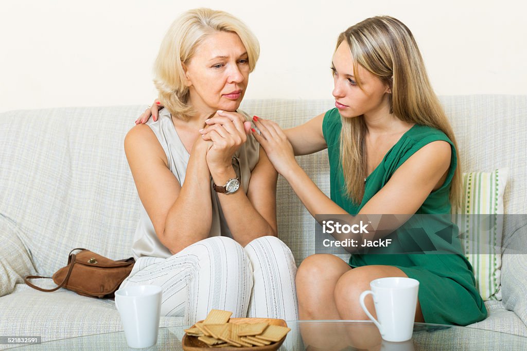 Mother tries reconcile with daughter Mature mother and adult daughter tries reconcile after quarrel at home 20-29 Years Stock Photo