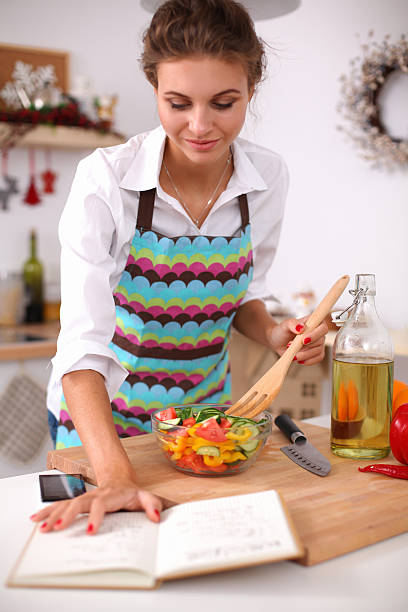 istock Smiling young woman  mixing fresh salad 521833647