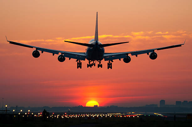 avión aterrizando con sunrise - runway airplane landing landing light fotografías e imágenes de stock