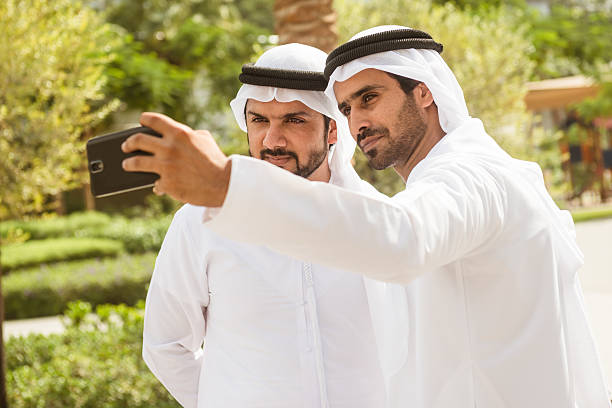 couple of sheikh friends doing a selfie on the city couple of sheikh friends doing a selfie on the city muslim photographer stock pictures, royalty-free photos & images