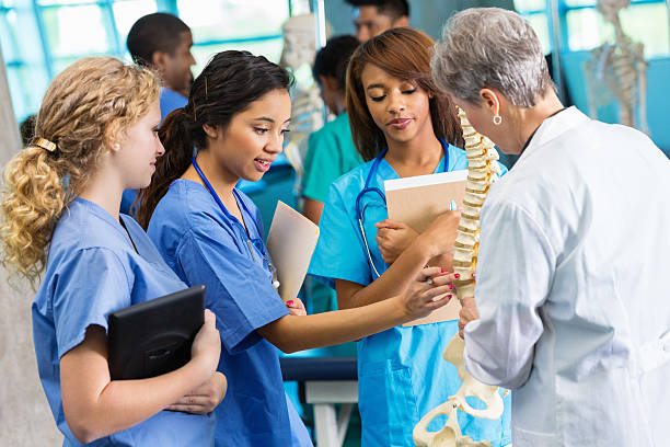 Medical school professor using model to teach nursing students Medical school professor using model to teach nursing students human spine photos stock pictures, royalty-free photos & images