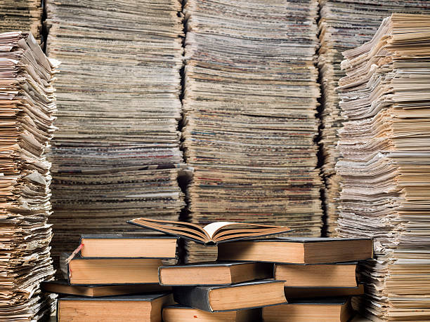 istock Huge stack of hardcover books and newspapers in library 521850239
