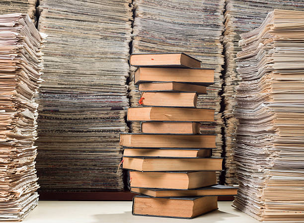 istock Huge stack of hardcover books and newspapers in library 521851869