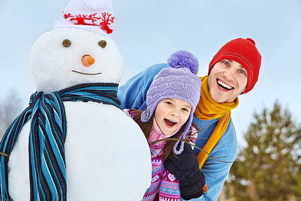 istock Father and daughter with snowman 521852239