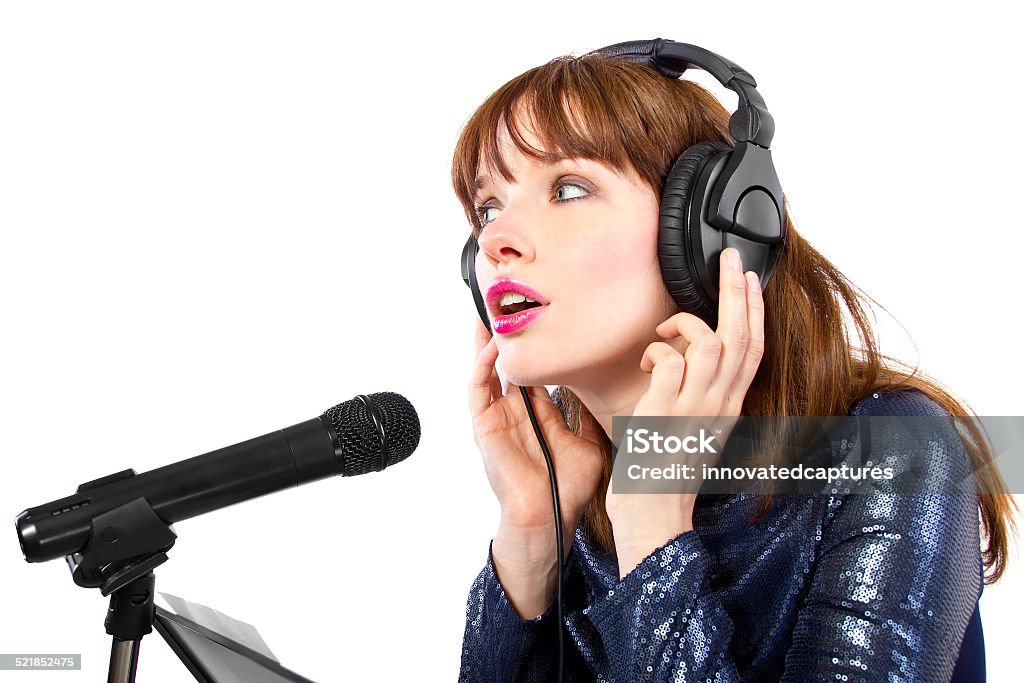Female Singer on a White Background stylish woman singing or reading a script for voice over with headphones and a microphone on white background Noise Stock Photo