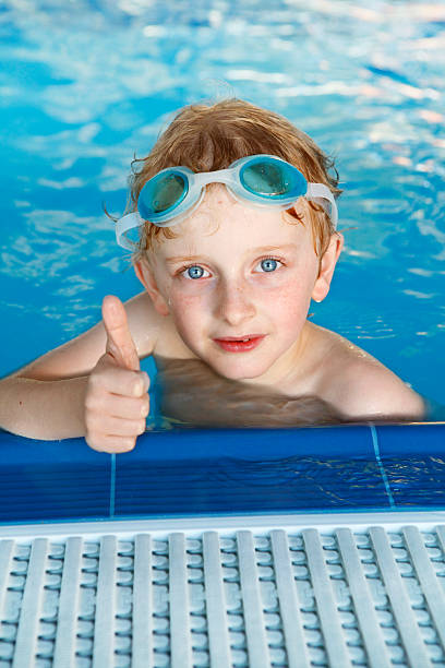 istock Boy in the swimming pool with thumb up 521853723