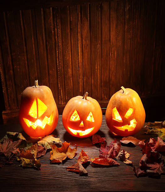 istock Jack o lanterns  Halloween pumpkin face on wooden background 521854363