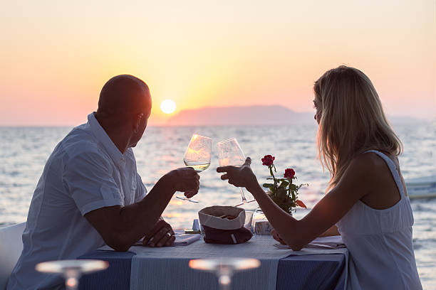 Dating couple drinking wine at sunset stock photo