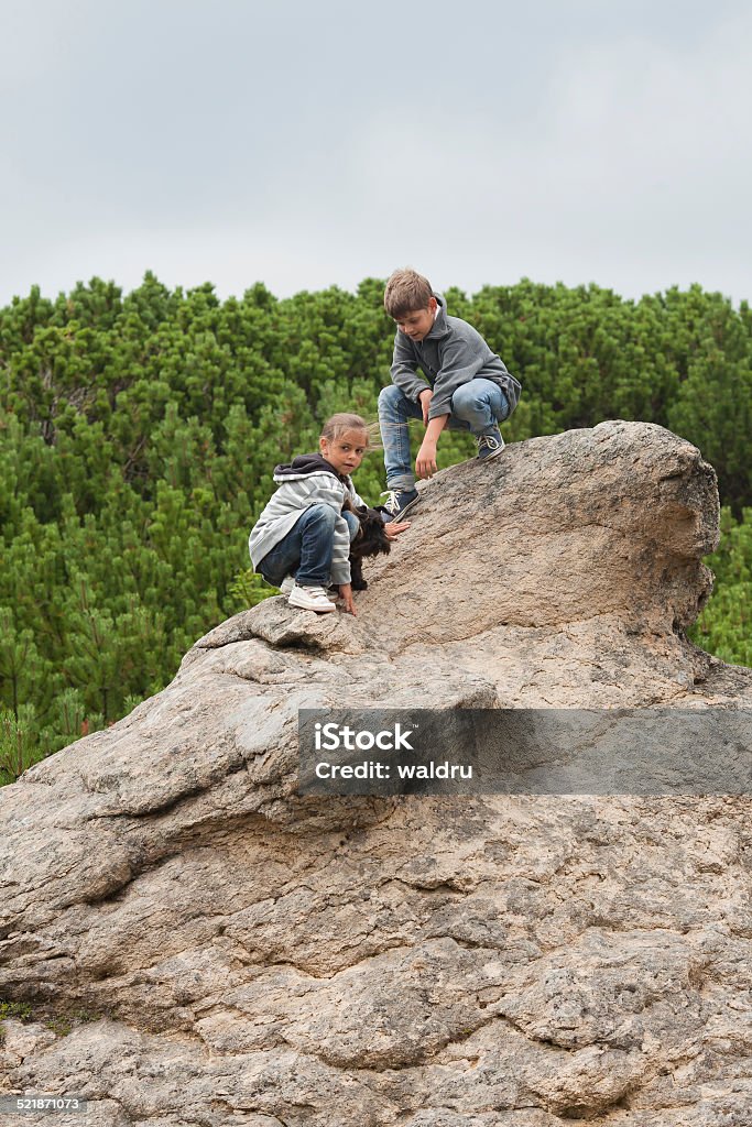 Children on cliff Children resting after hiking up mountain Achievement Stock Photo