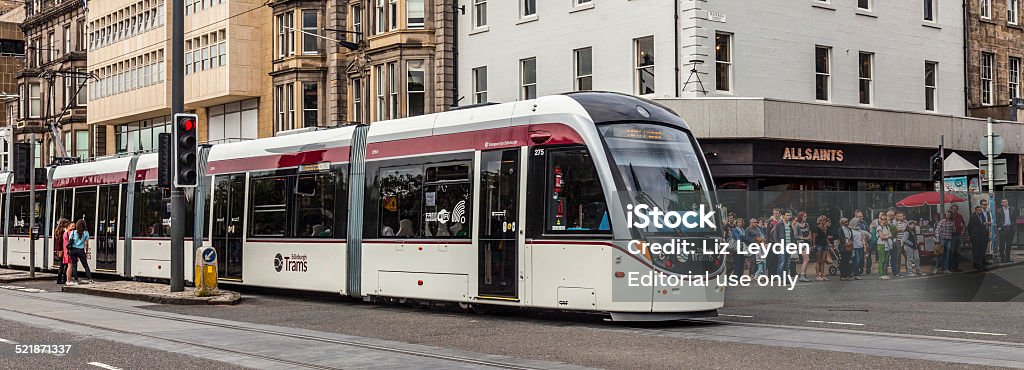 Public Transport - Tram in Princes Street, Edinburgh Edinburgh, Scotland, UK - 8th August 2014: A tram (CAF Urbos 3) travelling along Princes Street in central Edinburgh. Several people are waiting to cross Frederick Street. Edinburgh Trams became operational in May, 2014, and are run by Transport for Edinburgh Cable Car Stock Photo