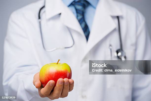 Doctor With An Apple Stock Photo - Download Image Now - Adult, Camera - Photographic Equipment, Confidence