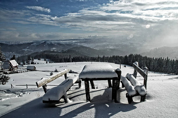 istock Snow covered table and benches in the mountains 521875699