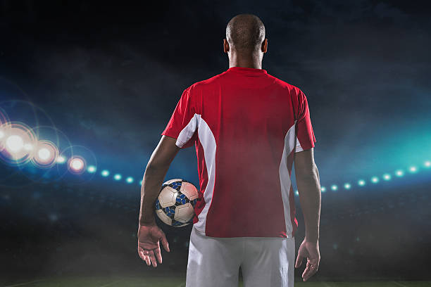 Professional player Professional soccer player with a ball standing on the stadium, rear view professional sportsperson stock pictures, royalty-free photos & images