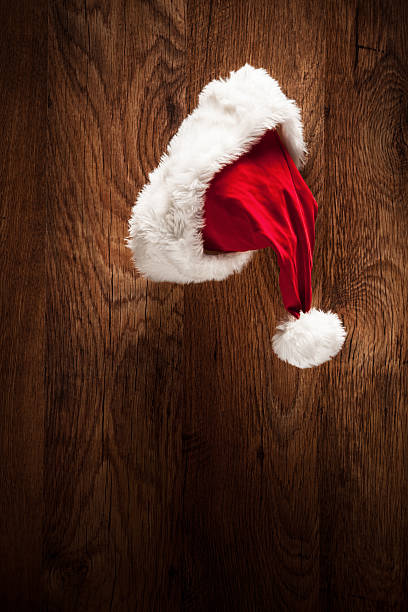 istock Santa hat hanging on a wooden surface 521891307
