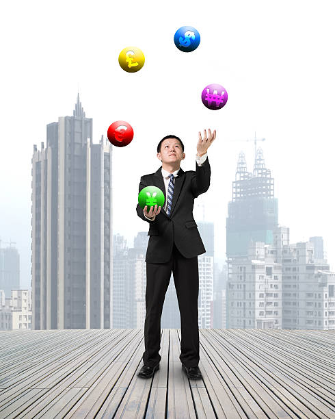 istock businessman throwing and catching currency symbol balls 521894361