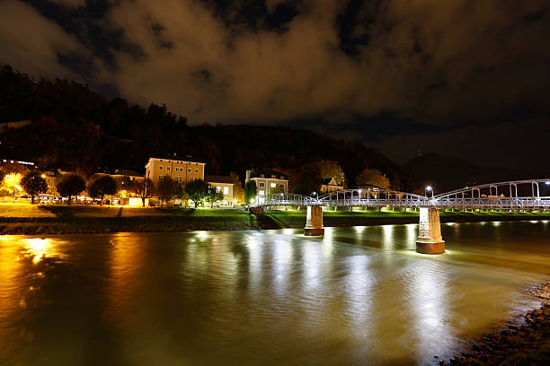 A night view of Salzburg next to the Mozartsteg bridge over the Salzach river with the Hohensalzburg castle in background. Austria.