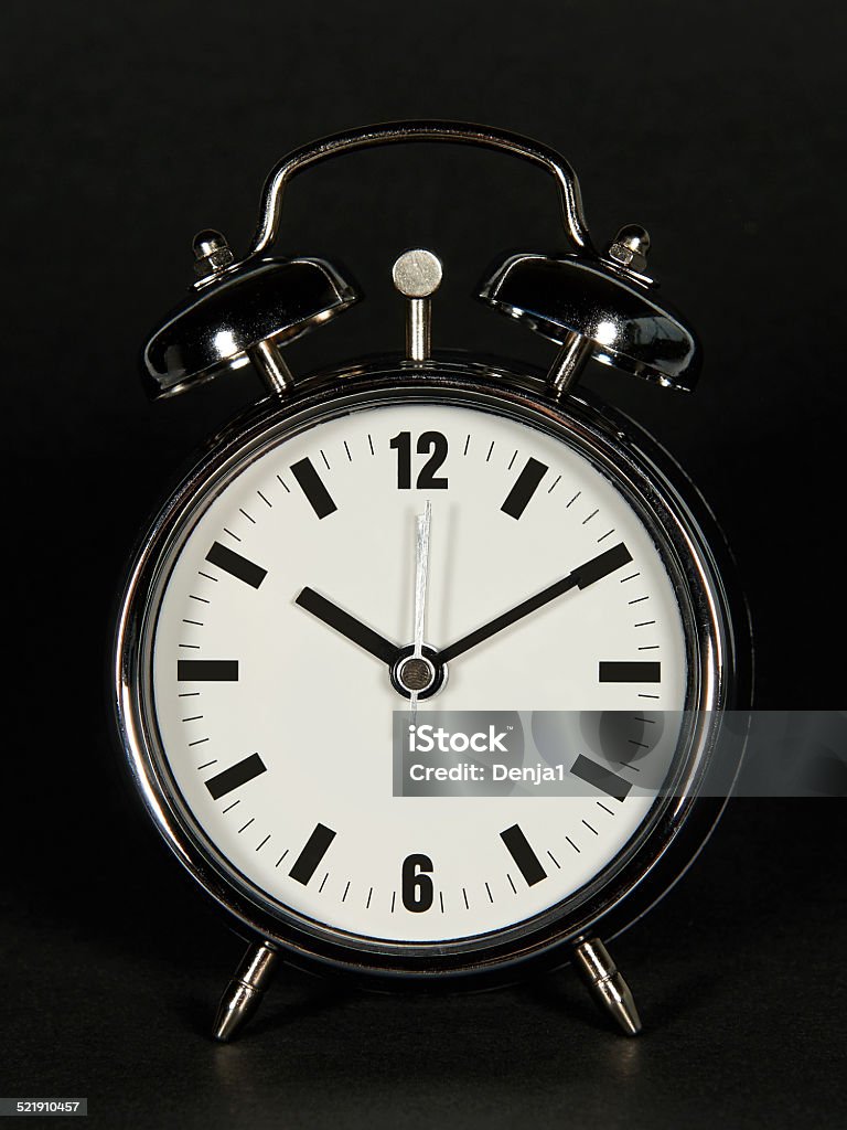 Chrome alarm clock Chrome alarm clock with a dark background Clock Stock Photo