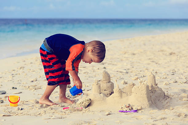 istock little boy building sand castle on beach 521933075