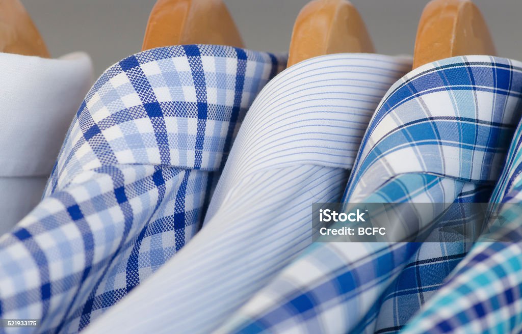 Mens dress shirts on hangers A row of men's dress shirts on hangers Button Down Shirt Stock Photo
