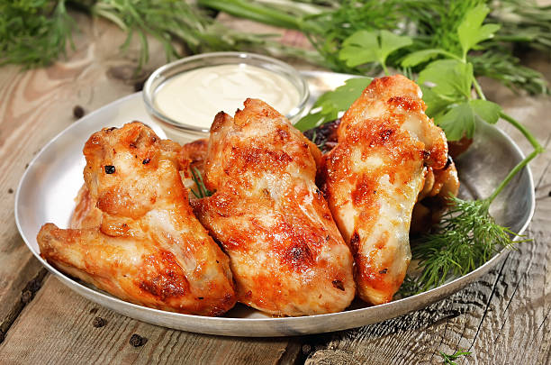 istock Baked chicken wings with sauce on wooden table 521934397