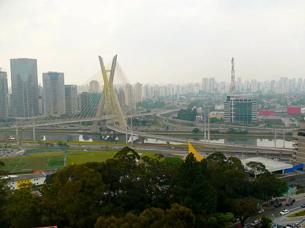 Part of the Marginal Pinheiros, showing the cable-stayed bridge, river pines, traffic and buildings in the city of Sao Paulo, Brazil. in 2014