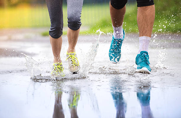 couple courir par mauvais temps - courir sous la pluie photos et images de collection