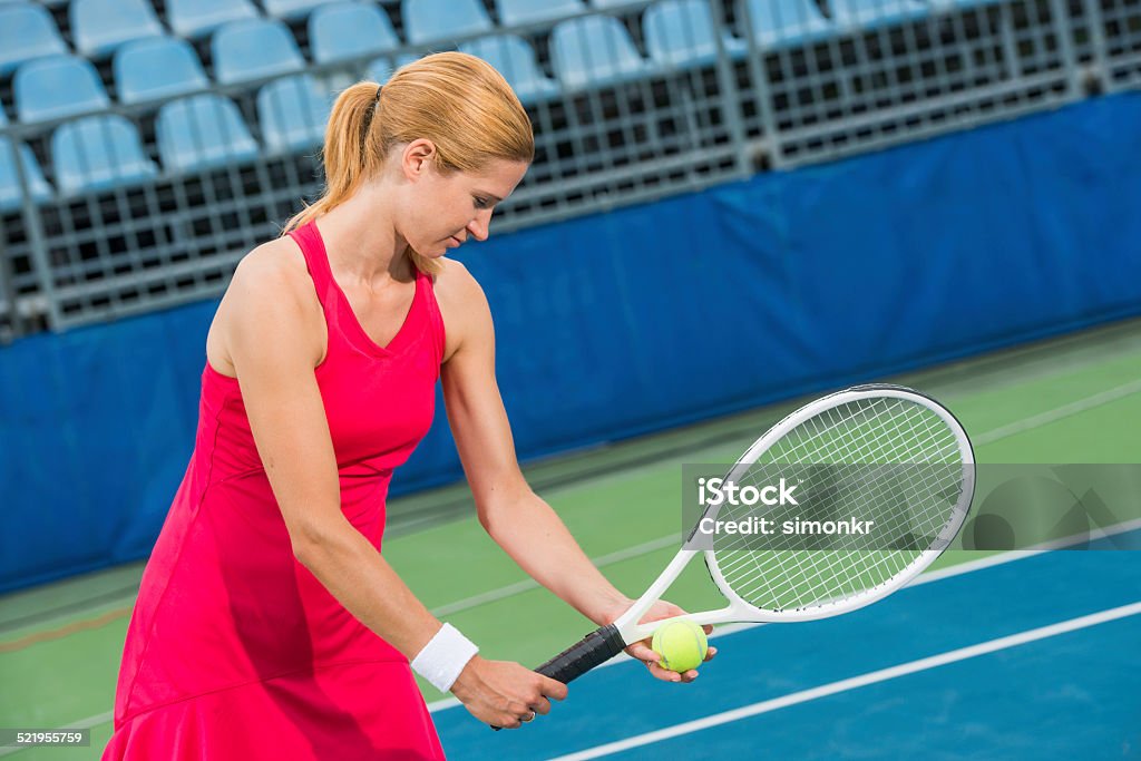 Tennis Player Serving The Ball Professional tennis player preparing for serving a ball on a tennis court. Activity Stock Photo