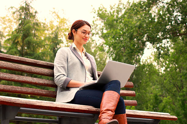 istock Woman in park with laptop 521957785