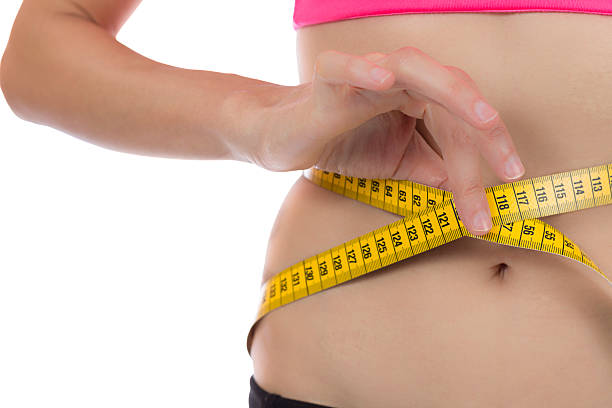 donna di perdita di peso con un nastro di misura - chilogrammo foto e immagini stock
