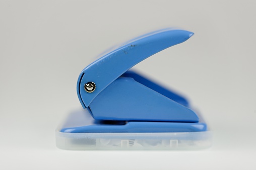 This is a photo of a blue hole punch / puncher. (end view) Office equipment / stationary