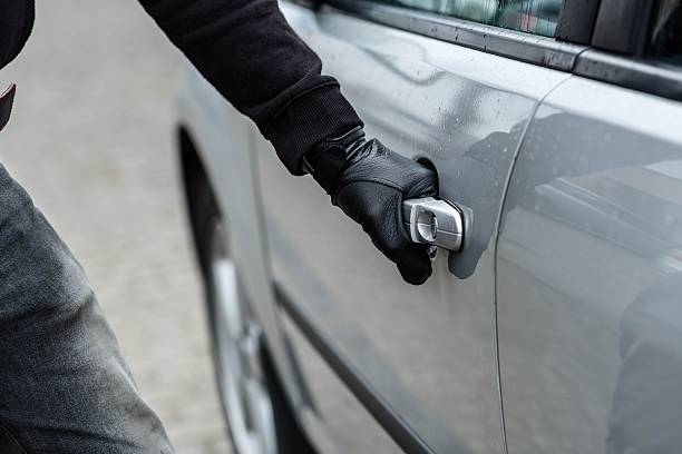 ladrão de carro mão, puxando o punho de um carro - burglary imagens e fotografias de stock