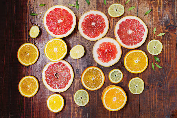 istock Vibrant citrus half cut fruits on old wooden table 521975670