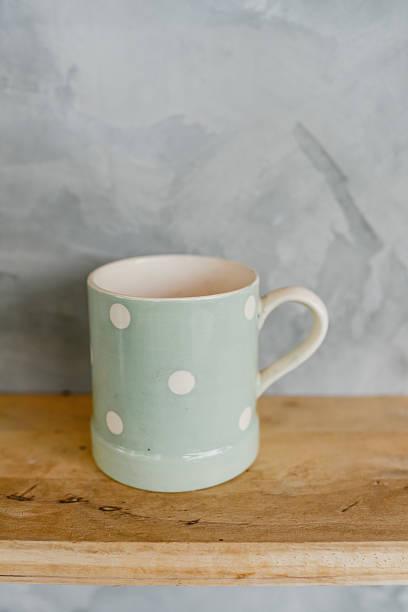 istock Pastel Green cup with dot on wooden background 521976229