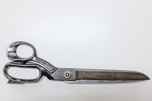 Closeup of metallic scissors over white background