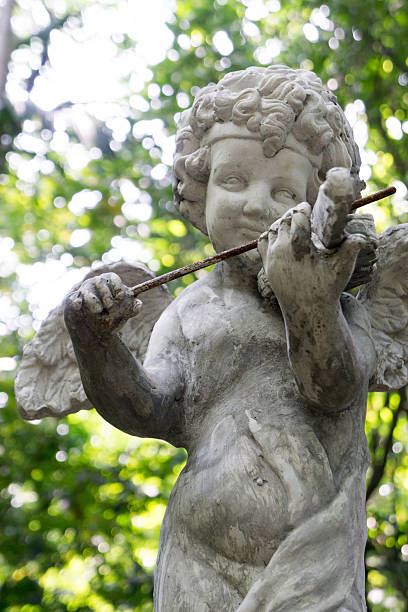istock Decorative cupid playing violin sculpture in the garden 521977009