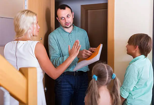 Desperate big family and irritated inspector having conversation at entrance