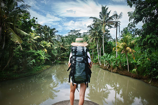 istock Woman with backpack near tropical river 521977832