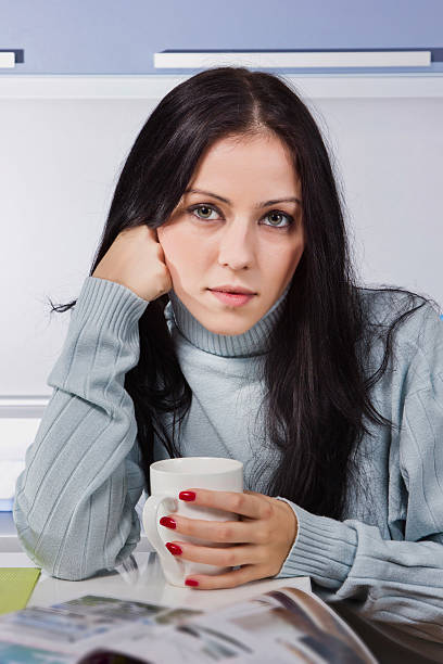 istock Young beautiful woman drinking coffee in the kitchen 521978942