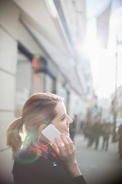 kobieta rozmawiająca przez telefon komórkowy na ulicy miasta - street fog profile zdjęcia i obrazy z banku zdjęć