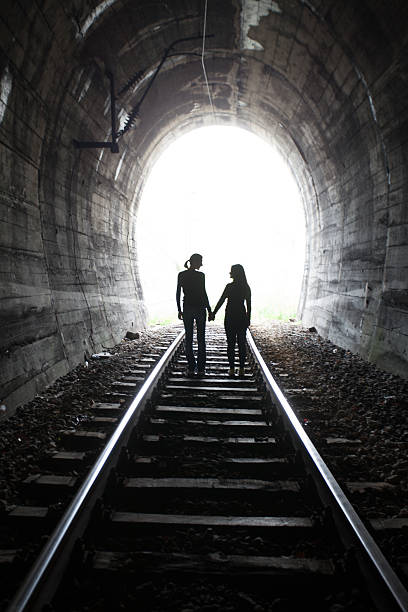 istock Couple walking together through a railway tunnel 521983916