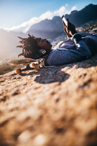 istock African American Resting and Looking at Smartphone at Seaside 521984196