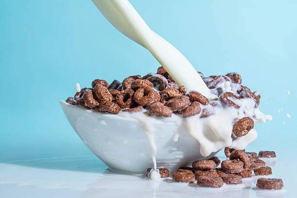 istock Milk stream pouring into chocolate flakes, blue background 521984656