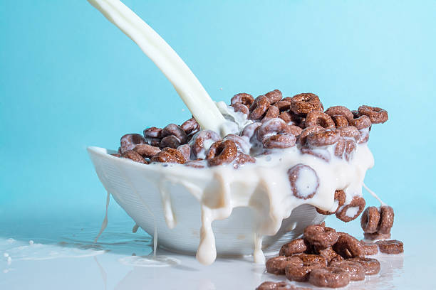 istock Milk stream pouring into chocolate flakes, blue background 521985102