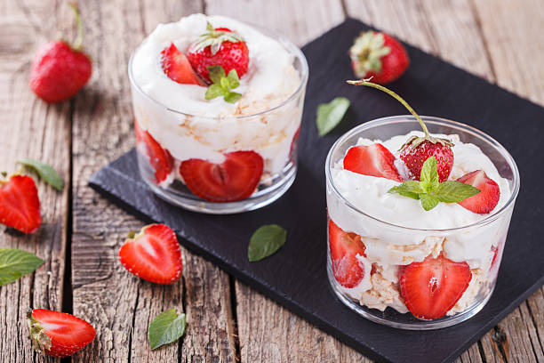 Eton Mess - Strawberries with whipped cream Eton Mess - Strawberries with whipped cream and meringue in a glass beaker. Classic British summer dessert.selective focus trifle stock pictures, royalty-free photos & images
